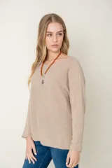 Sweater de lana color beige, de corte holgado y mangas largas.