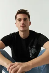 Remera negra de algodón con estampado en el frente y la palabra "CONNECT" estampada verticalmente en blanco en el lateral izquierdo.