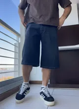 Bermuda de jean azul oscuro, corte ancho a la rodilla.