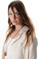 Camisa verde militar de manga larga con puños color crema, cuello clásico y cierre frontal con botones. Tiene un bolsillo en el pecho con bordado de una palmera color crema.