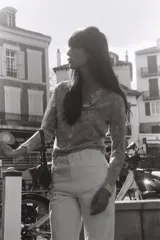 Cárdigan de punto con estampado floral en tonos rosa, gris y blanco. Tiene cuello redondo, manga larga, rib en los puños y el bajo, y cierre frontal con botones.