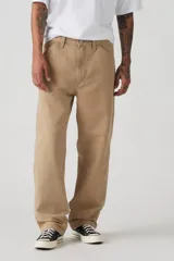 Pantalón de trabajo color beige, de corte recto y holgado, con bolsillos laterales y traseros.