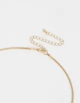 Cadena dorada con dije de corazón dorado adornado con strass de colores.