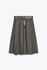 Falda midi color blanco hueso, de tiro alto y corte evasé. Incluye cinturón negro con hebilla metálica.
