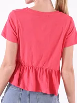 Blusa de algodón color fucsia con corte peplum y bolsillo frontal.