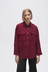 Camisa color crudo de viscosa, corte holgado, con cuello camisero, cierre frontal con botones, manga larga y dos bolsillos con solapa en el pecho.