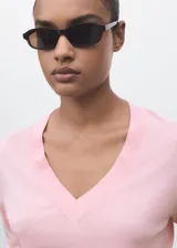 Jersey de punto fino color rosado, de manga larga y cuello en V, con corte recto.