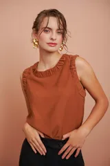 Blusa color ladrillo sin mangas con escote redondo y volados en los hombros.