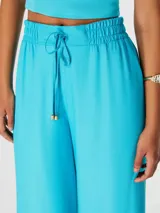 Pantalón celeste de corte palazzo con cintura elastizada y cordón ajustable.