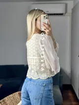 Camisa color crema con detalles de encaje y mangas largas abullonadas de gasa.
