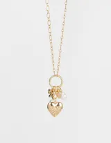 Collar dorado con cadena de eslabones y dijes colgantes: corazón con diseño floral, moño, perla y dije con forma de hoja.