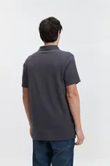 Chomba gris con textura tipo waffle, corte regular y logo bordado en el pecho.