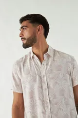 Camisa de hombre estampada, de manga corta y fit slim. Presenta cartera abotonada y logo bordado.