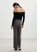 Pantalón de vestir azul marino con finas rayas verticales blancas, corte recto, tiro medio, lazo a la cintura y cierre de gancho y cremallera.