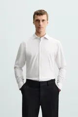 Camisa celeste a rayas verticales blancas, de corte recto, con cuello italiano abierto, mangas largas con puños abotonados y cierre frontal con botones.