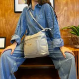 Bandolera negra de símil cuero con dos bolsillos frontales con cierre, un bolsillo trasero y tres bolsillos internos. Incluye correa larga regulable de símil cuero a tono.