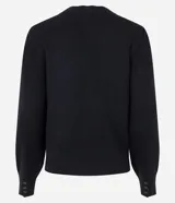 Suéter negro de punto con cuello redondo con acabado en forma de nube, manga larga con pliegues en los hombros y botones en los puños.