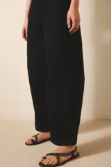 Pantalón jean negro de tiro medio y calce holgado, confeccionado en denim rígido con lavado suavizado.