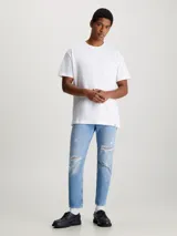Pantalón de jean celeste con roturas, de corte recto y tiro medio.