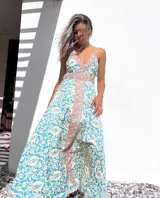 Vestido largo de tirantes con estampado floral en tonos celeste, blanco y rosa. Tiene escote halter y espalda descubierta con lazos.