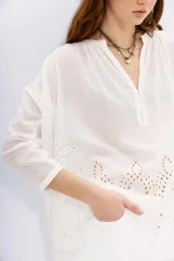 Camisa negra amplia de algodón con escote redondo y abertura corta con botones en el frente. Cuenta con bordados cut-out en el ruedo y mangas largas terminadas en puño con botón.