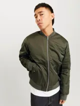 Campera bomber color verde oliva, con cuello estilo baseball, mangas largas con puños acanalados y cierre con cremallera. Tiene bolsillos al frente con botón y bolsillo en la manga.