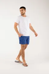 Short de baño azul con estampado de hojas de palmera en tonos azules, blancos y rosados.