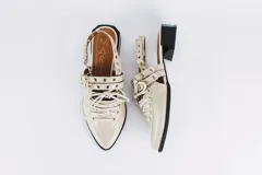 Sueco de cuero negro con cordones, ojales, hebillas y tira trasera regulable con elástico. Tiene taco cuadrado bajo.