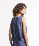 Musculosa de jeans color azul con recortes y cierre por botón.