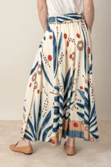 Pollera larga de viscosa color crudo con estampado de hojas azules y detalles en marrón y rojo.