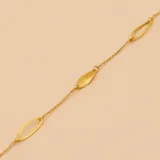 Pulsera de oro amarillo 9k con cadena de eslabones y dijes ovalados calados y dijes sólidos en forma de hoja.