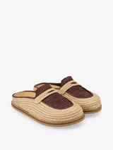 Mules artesanales tejidas a mano en raffia color beige y negro, con diseño cómodo y flexible, suela liviana y estilo relajado.