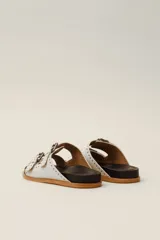 Sandalias marrones de cuero vacuno con doble tira y hebillas metálicas ajustables.
