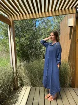 Vestido camisero amplio y largo de lino color azul, con botones de nácar, cuello camisero y bolsillos laterales.