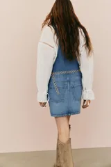 Jumper corto de denim azul, con breteles ajustables con cierre de metal, bolsillo superior de parche, bolsillos al bies y bolsillos abiertos atrás.