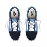 Zapatillas Vans Old Skool de lona azul y puntera de gamuza negra, con la clásica sidestripe blanca de cuero en los laterales y suela de goma blanca con línea negra.