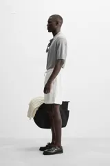 Bermuda negra regular fit confeccionada en tejido de algodón con estructura. Cintura elástica ajustable con cordón, bolsillos laterales y bolsillo trasero de vivo.