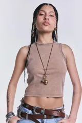 Musculosa corta color beige con cuello redondo y sisas con detalle de tachas plateadas.