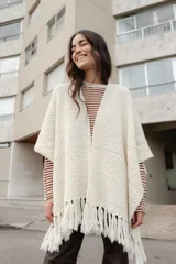 Ruana tejida en lana merino color amarillo pastel, con terminación de flecos.