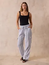 Pantalón cargo de lino color blanco, marca Marissa Olivia. Tiene pretina ancha elastizada con lazo de ajuste, bolsillos inclinados delanteros y bolsillos laterales con botón.