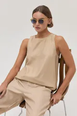 Pantalón chino de lino metalizado color beige, tiro medio-alto y pierna recta. Cuenta con bolsillos laterales y traseros.