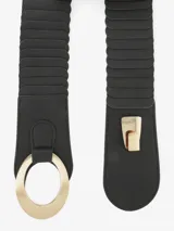 Cinturón ancho de elástico negro con apliques de cuero sintético y hebilla circular dorada.