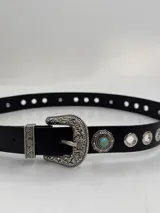 Cinto negro de cuero con hebilla metálica labrada estilo western, con apliques de medallones plateados con turquesas y ojalillos metálicos.