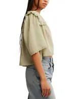 Blusa blanca de algodón con escote en V, mangas cortas y detalle de bordado tipo encaje.