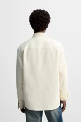 Camisa color crudo de algodón con acabado cepillado, corte relaxed fit, cuello solapa, manga larga con puño abotonado, bolsillo de parche en el pecho, efecto lavado y cierre frontal abotonado.