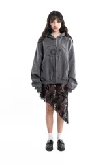 Campera gris de algodón con cierre frontal, capucha y bolsillos tipo canguro. Tiene costuras a la vista, remaches y bordado.