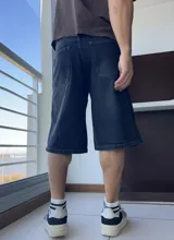 Bermuda de jean azul oscuro, corte ancho a la rodilla.