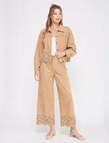 Pantalón de tiro alto color beige, de corte ancho y ruedo con diseño calado.