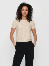 Camiseta color beige con tejido calado, de manga corta y cuello redondo.