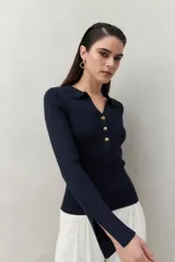 Sweater azul marino de punto acanalado con cuello tipo polo y botonadura frontal dorada. Mangas largas con aberturas en los puños.